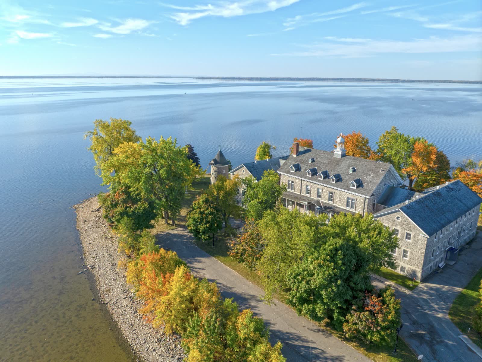Manoir patrimonial en bord de fleuve photographié par drone à l'automne
